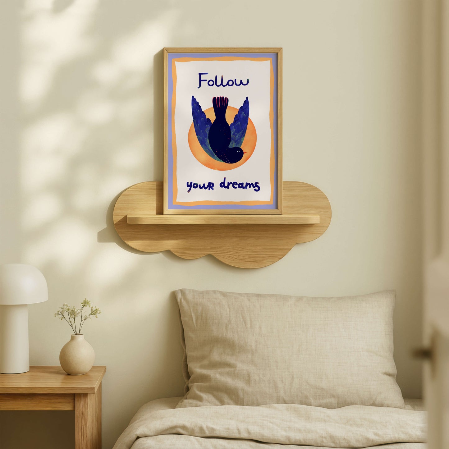 Framed artwork with motivational quote on a wall above a bed