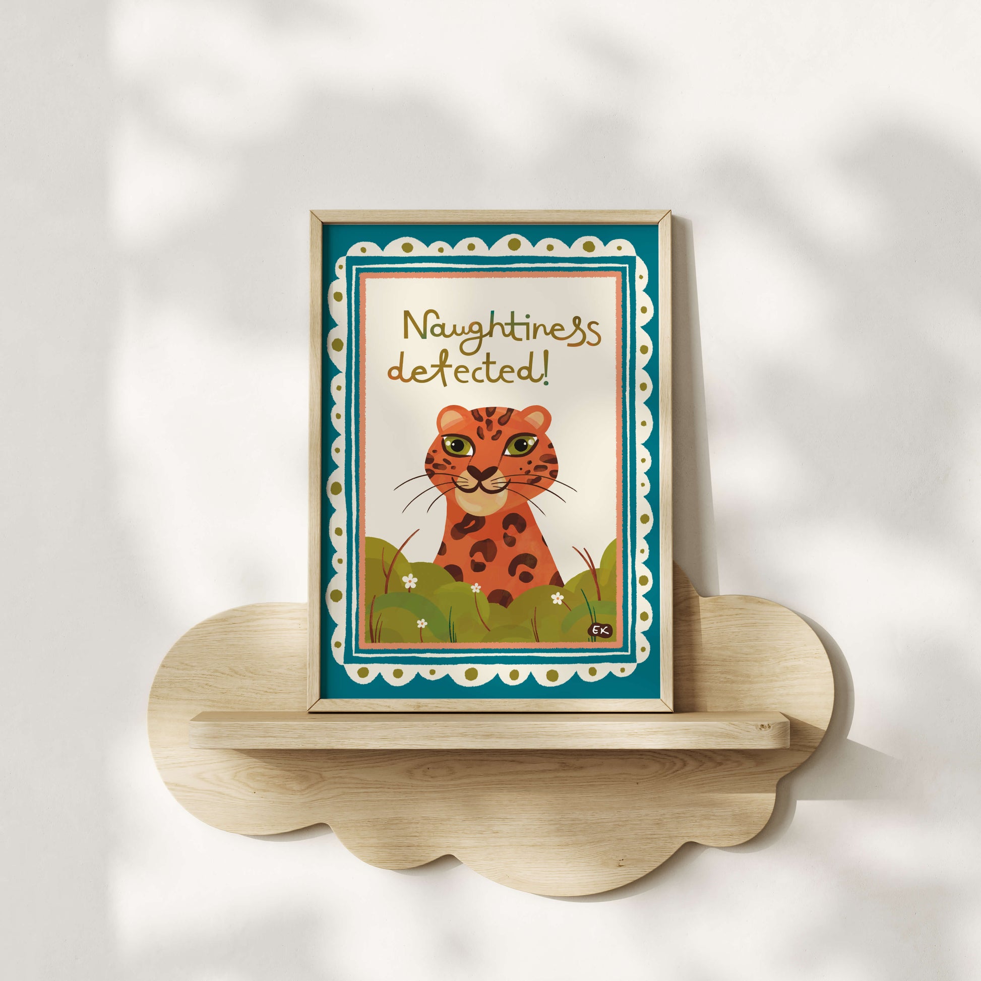 Framed artwork with a cheeky leopard and text 'Naughtiness detected!' on a white wall.
